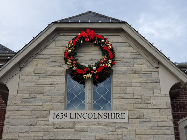 A red-bowed wreath crowns the gable