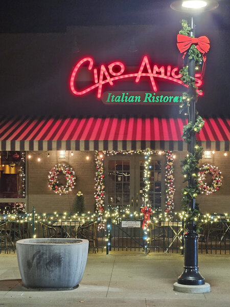 Ciao Amici's aglow beneath striped awnings